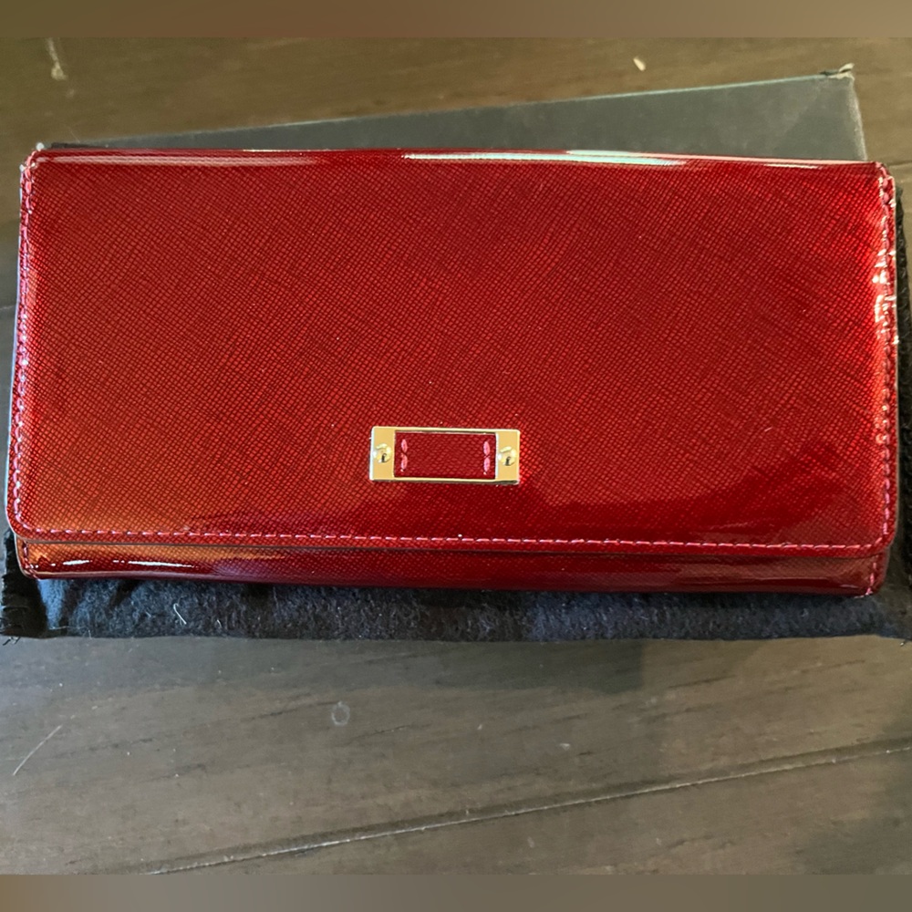 Red Tumi patent leather wallet with dust bag and original box.